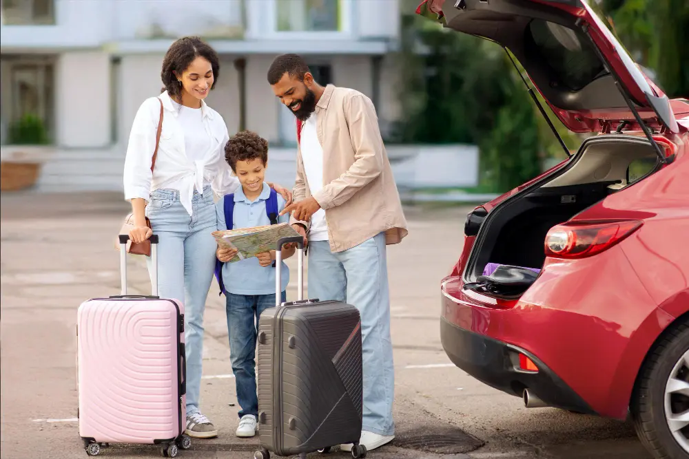 A family of five with luggage and a stroller loading into a private SUV