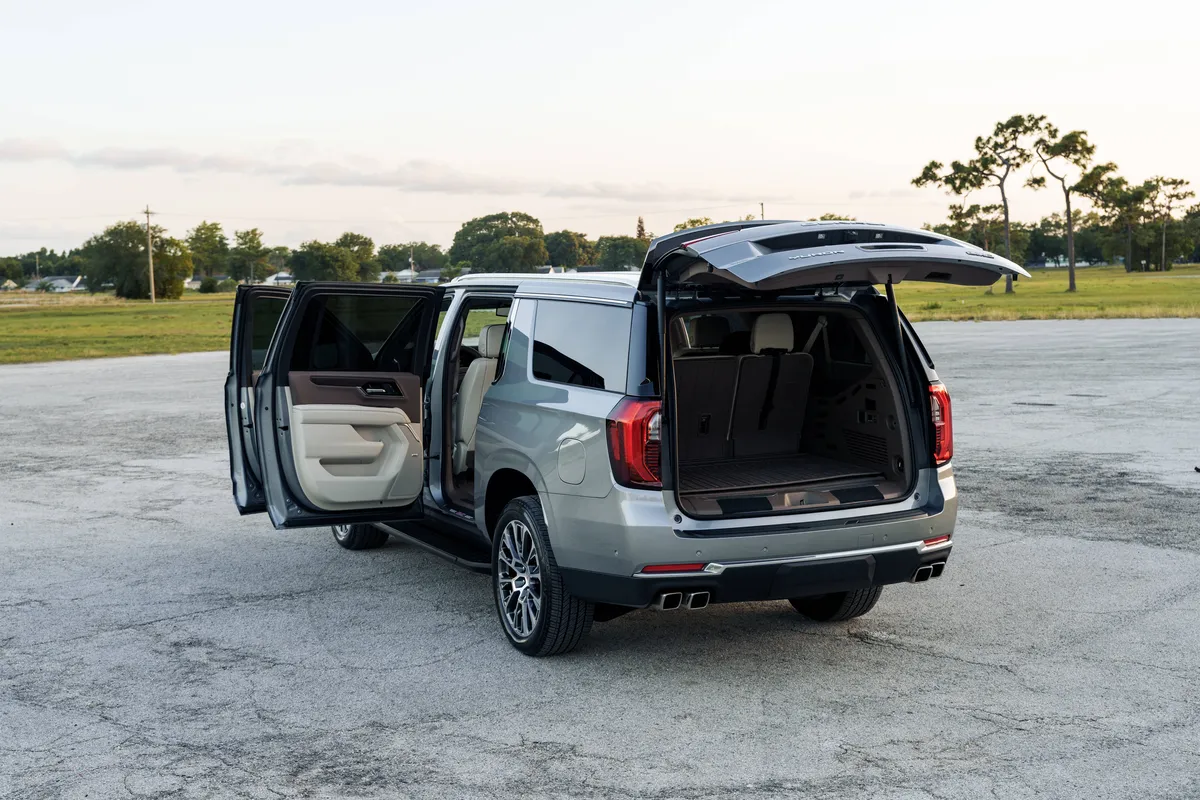 Back view of a premium private vehicle with an open trunk, showing spacious luggage capacity for MCO to Epic Universe transfers by The Genie