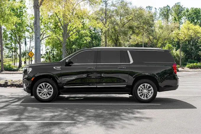 Side profile of a premium Cadillac Escalade luxury SUV, providing exclusive private airport and resort transfers by The Genie.